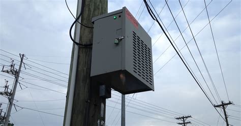 steel box on pole on side of road|mystery box on utility pole.